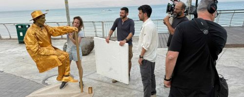 אנשים מביטים בפסל מזהב במדרחוב